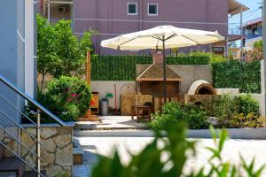 eine Terrasse mit einem Tisch und einem Sonnenschirm in der Unterkunft IDEAL HOUSE & APARTMENTS in Ksamil
