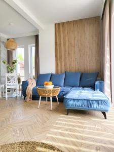 ein Wohnzimmer mit einem blauen Sofa und einem Tisch in der Unterkunft Błękitna Dębki in Dębki