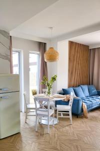 ein Wohnzimmer mit einem blauen Sofa und einem Tisch in der Unterkunft Błękitna Dębki in Dębki