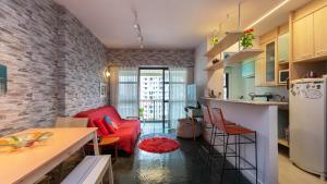 cocina y sala de estar con sofá rojo en Apto com lazer prox a Praia da Barra da Tijuca RJ, en Río de Janeiro