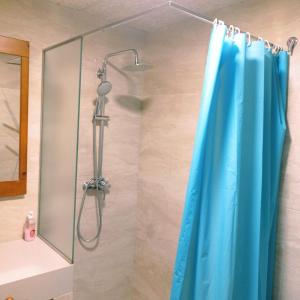 a shower with a blue shower curtain in a bathroom at Allotjament Buixeda in Olot +20 photos