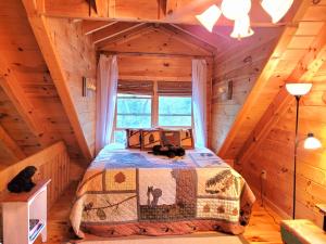 ein Schlafzimmer mit einem Bett in einem Blockhaus in der Unterkunft LUXURY CABIN WITH WATERVIEW AND PRIVACY, hiking in Blue Ridge