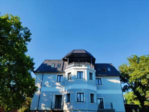 ein blaues Haus mit Balkon darüber in der Unterkunft Villa Philip Noir in Révfülöp