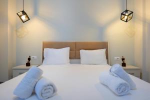 ein Schlafzimmer mit einem weißen Bett und Handtüchern darauf in der Unterkunft IDEAL HOUSE & APARTMENTS in Ksamil