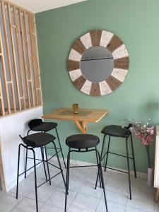 een tafel en vier stoelen in een kamer met een spiegel bij Studio brignoles PISCINE emplacement idéal in Brignoles