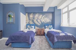 2 camas en una habitación azul con paredes azules en Sea View*Morden Central Brighton* Two Bedroom Flat *Roof Terrace* en Brighton & Hove