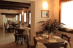 una sala da pranzo con tavoli e sedie in un ristorante di Farm stay Al Pisoler a Caneva