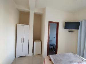 a bedroom with a bed and a door to a bathroom at suites montanha das letras in São Thomé das Letras