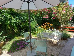 a patio with two chairs and an umbrella at Premantura Studio apartman in Premantura
