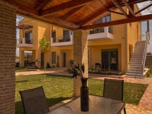 a patio with a table and chairs and a building at Nicolas Luxury Suites in Kourouta