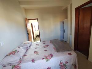 um quarto com uma cama com colcha floral em suites montanha das letras em São Thomé das Letras