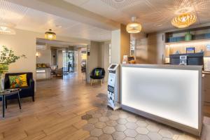 a lobby with a counter and a living room at BEST WESTERN La Porte des Châteaux in Meung-sur-Loire