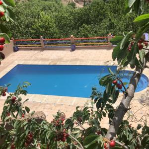 deux photos d'une piscine bleue avec banc dans l'établissement Jnane Karma, à Imlil