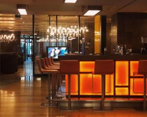 eine Bar in einem Restaurant mit orangefarbenen Barhockern in der Unterkunft Radisson Blu Hotel Istanbul Asia in Istanbul