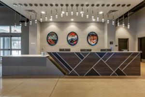 um lobby com um balcão com quatro pratos na parede em Vīb Hotel by Best Western Phoenix - Tempe em Tempe