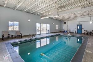 a large swimming pool in a large room with tables and chairs at Best Western Brighton Inn in Brighton