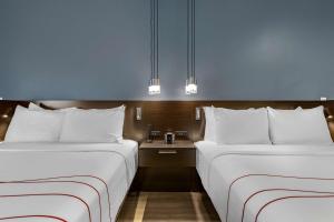 two beds in a hotel room with blue walls at Vīb Hotel by Best Western Phoenix - Tempe in Tempe
