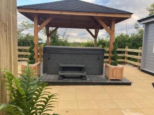 a wooden gazebo with a bench under it at Hilltop Hideaway in Donegal