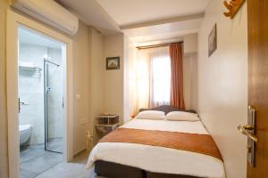 1 dormitorio con 1 cama y baño con ducha en Turna Hotel, en Estambul