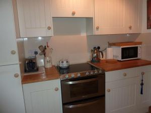 a kitchen with a stove and a microwave at Taigh Geal in Stornoway +40 photos