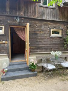 een houten huis met een deur en een tafel en stoelen bij Vaide in Vaide