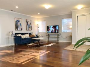 ein Wohnzimmer mit einem blauen Sofa und einem TV in der Unterkunft @ Marbella Lane - Elegant Home in SJ in San Jose