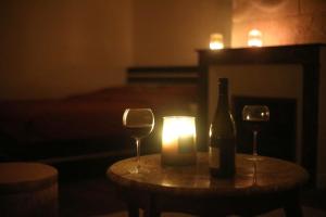 a table with a bottle of wine and two glasses at La Montrieuse, Chambre individuelle avec sauna et baignoire spa in Naveil