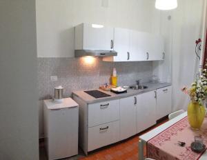 una pequeña cocina con armarios blancos y fregadero en B&B Stefyld, en Paola