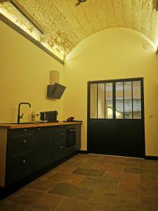 a kitchen with a black door and a window at La Montrieuse, Chambre individuelle avec sauna et baignoire spa in Naveil