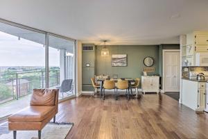 a living room with a table and chairs and a kitchen at 7th-Floor Omaha Condo with Balcony and Park Views in Omaha
