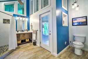 a bathroom with blue walls and a toilet and a sink at Mtn Treehouse with Fire Pit, Breathtaking Views in Waynesville +32 photos