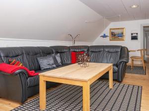 ファーンにある4 person holiday home in Fanのリビングルーム(黒い革張りのソファ、木製テーブル付)