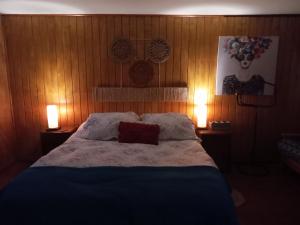 a bedroom with a large bed with two lamps at Cabaña Cerezo in Guayacán
