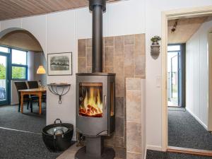a fireplace in the middle of a room at 6 person holiday home in Hvide Sande in Havrvig