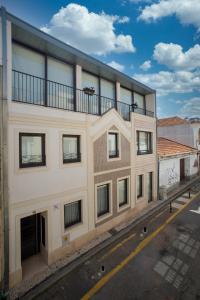 a white building with a balcony on top of it at Ria Sal apartments in Aveiro