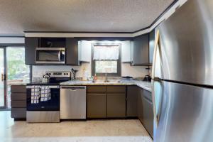 une cuisine avec un réfrigérateur en acier inoxydable et un évier dans l'établissement Sea Glen Cottage, à Oak Bluffs