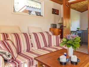 uma sala de estar com um sofá listrado e uma mesa em Holiday home Faxe Ladeplads VII em Fakse Ladeplads