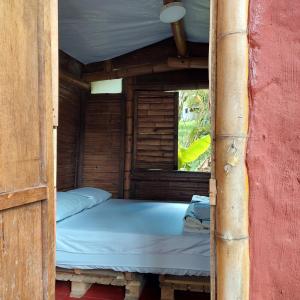 a bed in a wooden room with a window at Hostal La Pijaraña in Salento +25 photos