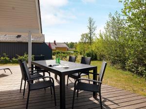 una terraza de madera con mesa y sillas. en 6 person holiday home in GROEMITZ, en Grömitz