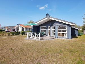 a blue house with a deck with a table at 6 person holiday home in GROEMITZ in Grömitz