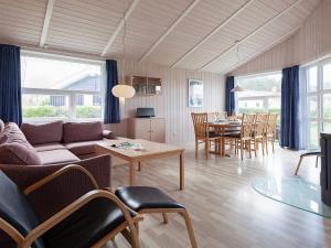 ein Wohnzimmer mit einem Sofa, einem Tisch und Stühlen in der Unterkunft Three-Bedroom Holiday home in Grömitz 6 in Grömitz