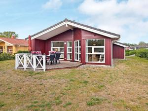 Casa roja con terraza con mesa y sillas en 6 person holiday home in GROEMITZ, en Grömitz