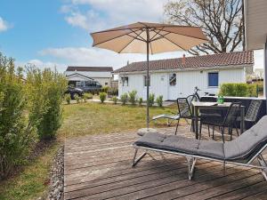 a patio with an umbrella and a table and chairs at Two-Bedroom Holiday home in Grömitz 18 in Grömitz