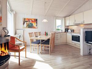 a kitchen with a table and chairs and a fireplace at Two-Bedroom Holiday home in Grömitz 18 in Grömitz