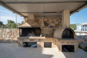 un horno al aire libre con una pared de piedra en Pine tree Apartment & sunset en Ágios Nikólaos