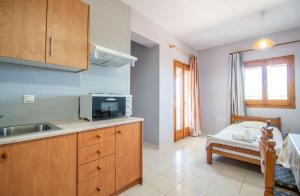 a kitchen with a sink and a microwave at Pine tree Apartment & sunset in Koiliomenos