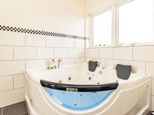 eine Badewanne in einem weiß gefliesten Bad in der Unterkunft 6 person holiday home in Fjerritslev in Fjerritslev