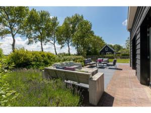 a patio with couches and a table and chairs at Family Home in Zeeland near Oranjezon Beach in Vrouwenpolder