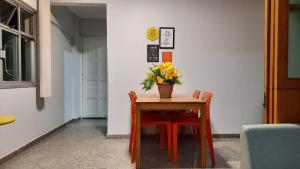 a table with chairs and a vase of flowers on it at Vem pra cá! Localização Privilegiada! in Guarapari