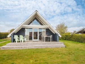 a blue house with a porch with chairs and a table at Two-Bedroom Holiday home in Hejls 10 in Hejls